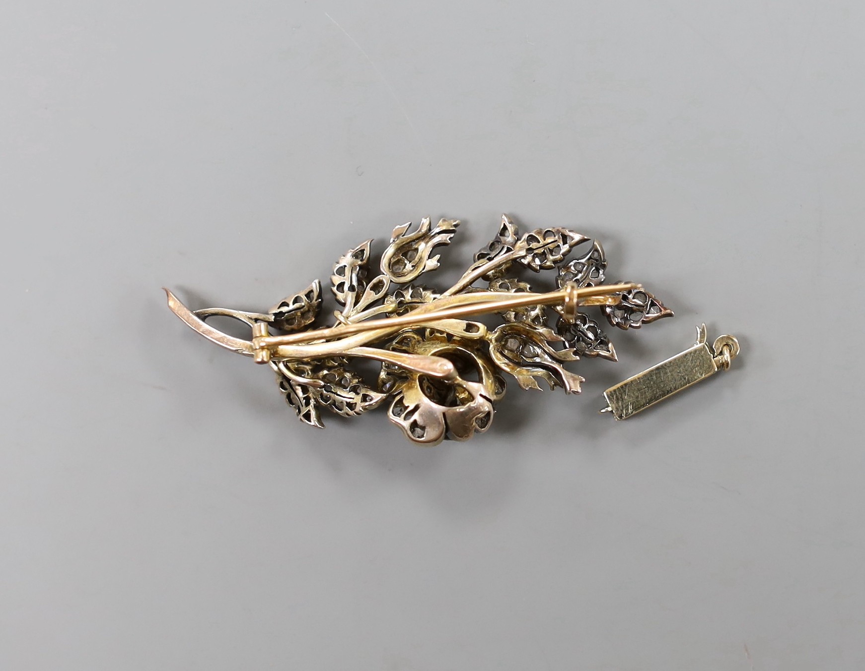 A late 19th/early 20th century yellow metal diamond chip set set floral spray brooch, 52mm, gross weight 10.8 gram and a diamond set clasp.